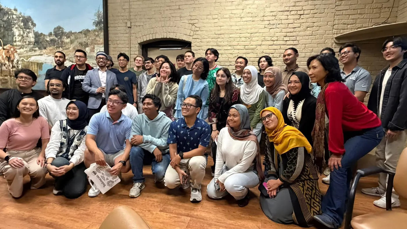 Big group of Indonesian students and families posing together indoors