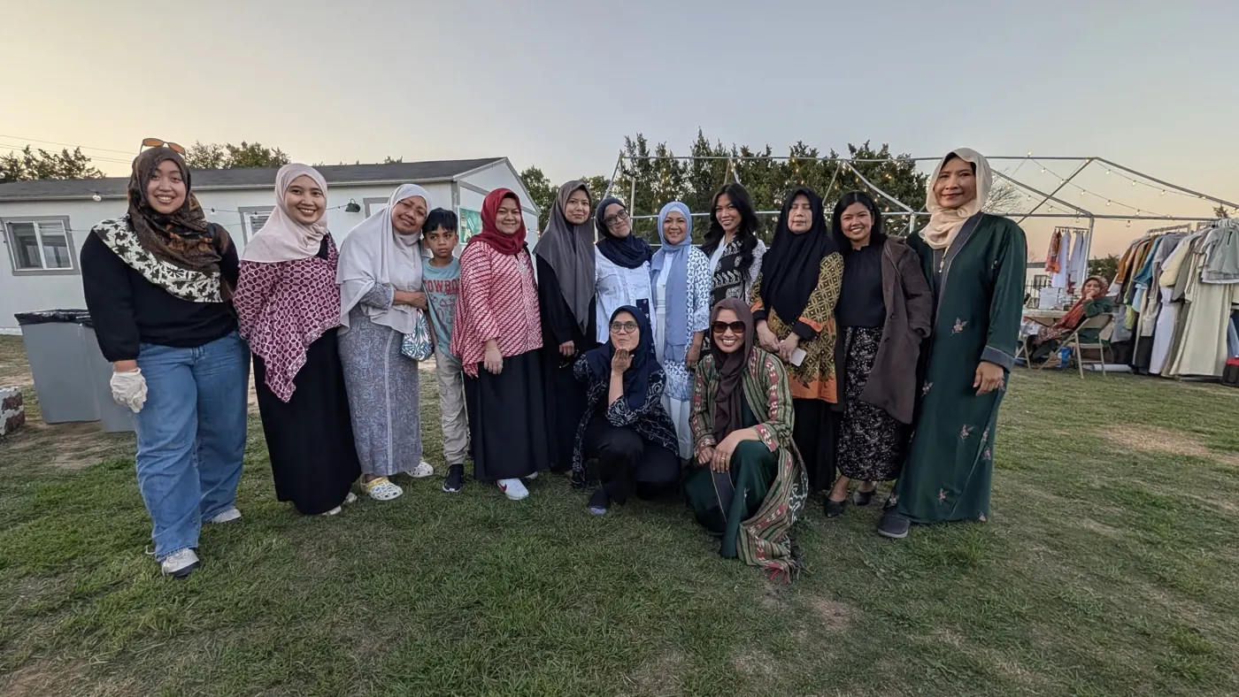 Ibu-ibu standing together on the grass at dusk