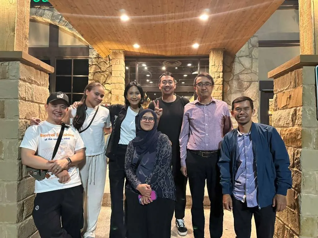 Members posing together at night outside a building